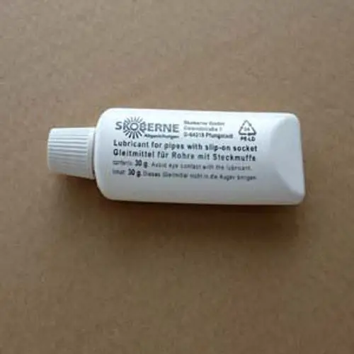 Weißer Tube mit Aufschrift "Lubricant for pipes with slip-on socket" und Hinweisen zur Anwendung. Marke Remeha ist nicht sichtbar.